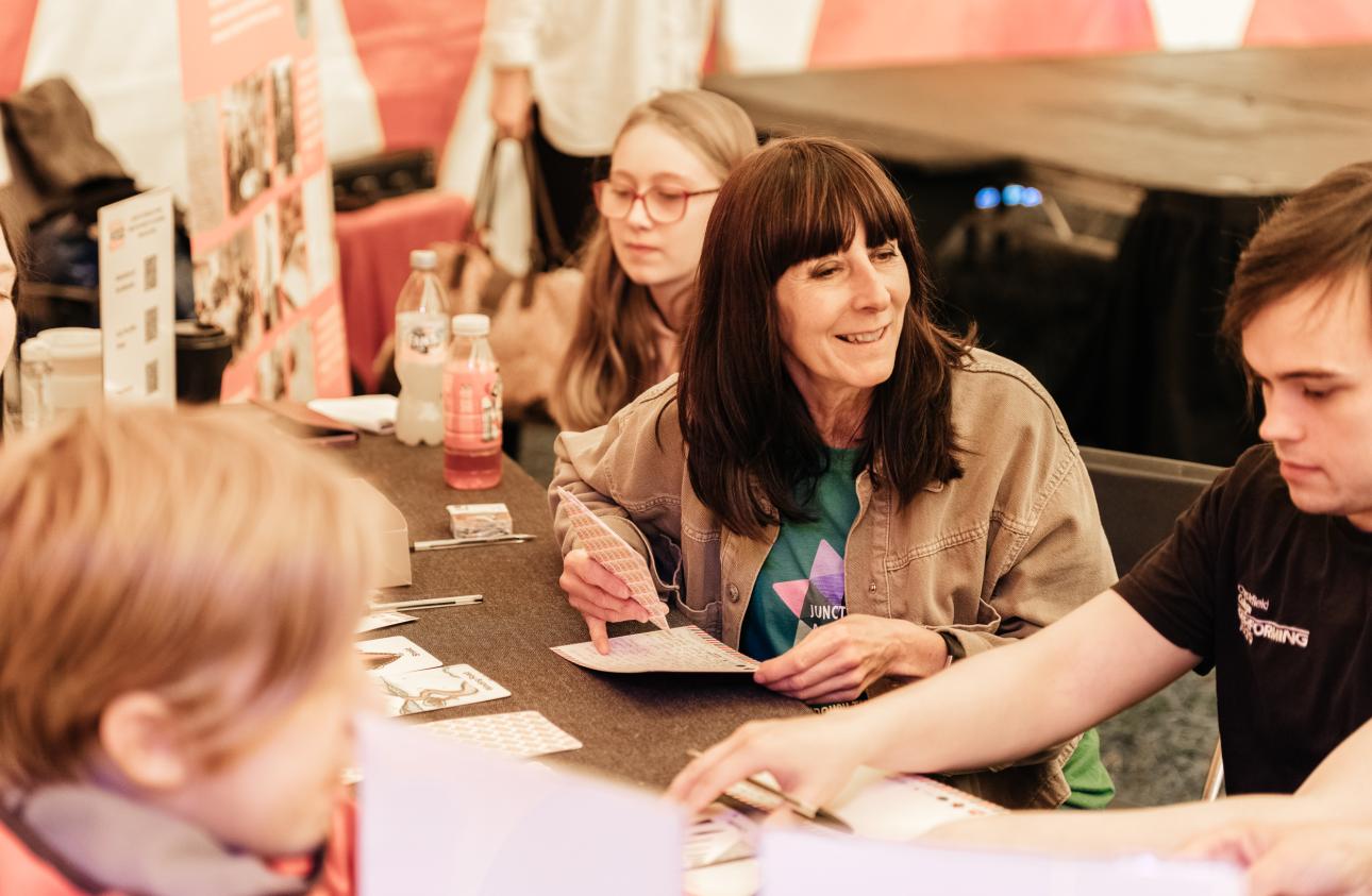 a table of activities with the story cards in the big top with Jane Well from Junction Arts at tapton lock festival